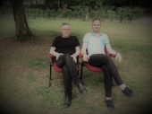 Edouard Manceau et Rudy Martel assis côte côte sur une chaise, dans un jardin